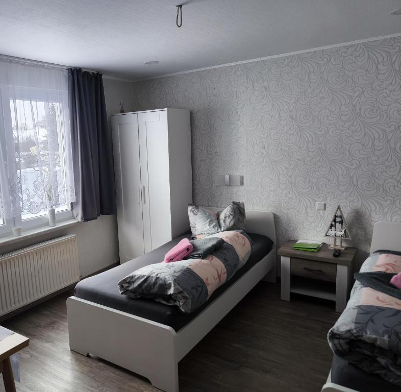 a small bedroom with a bed and a cabinet at Gästehaus Müller in Hohenleipisch