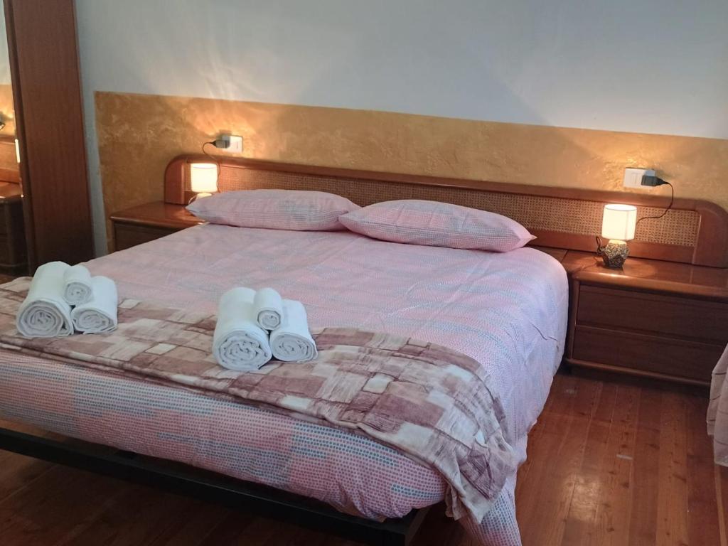 a bedroom with a bed with two towels and two lamps at I Pelosetti in Calalzo