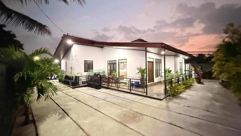 a small white house with a porch at night at Sunset Villa in Hambantota