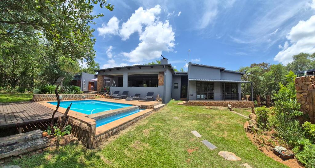 a house with a swimming pool in the yard at Brett's Place in Warmbaths