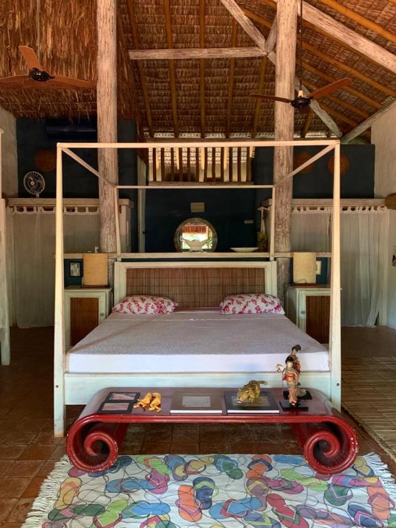 a bedroom with a white bed in a room at Bangalô 12 in Porto Seguro