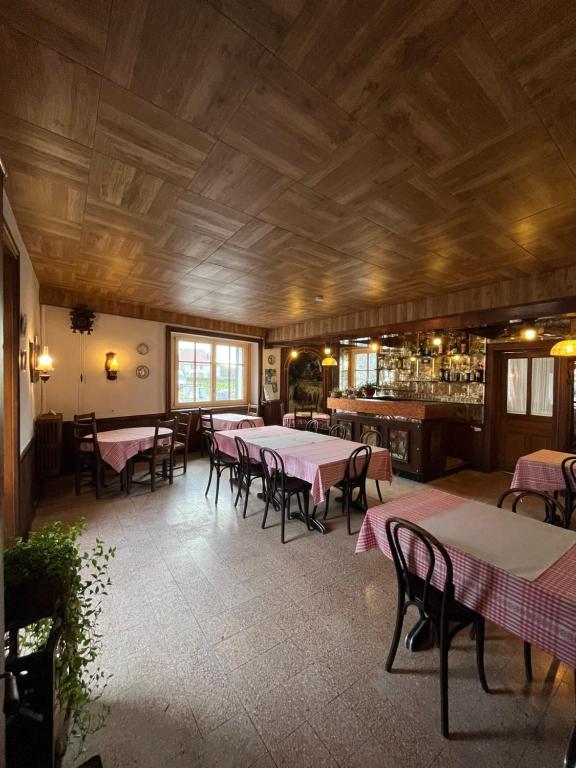 a restaurant with tables and chairs and a bar at Ancien hotel Bourgeois in Andelot-en-Montagne