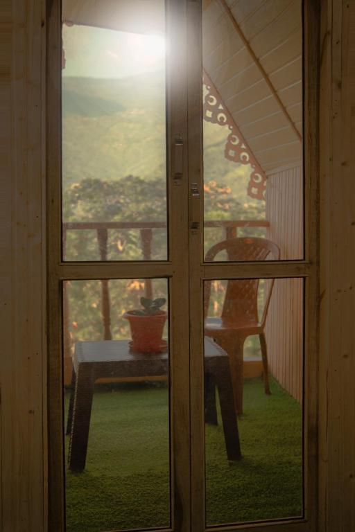 a glass door with a table and a chair outside at Open view home stay in Mangpu