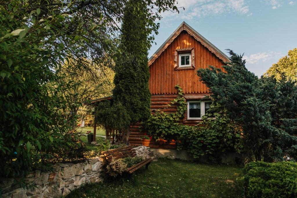 a wooden house with a tree in front of it at Domek "Kasieńka" in Stronie Śląskie