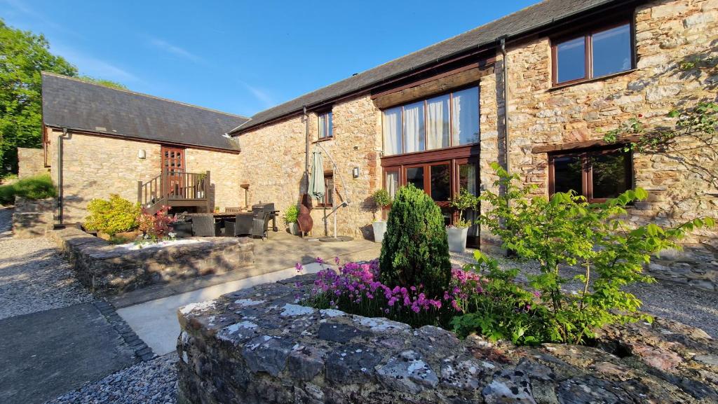 a stone house with a garden in front of it at Wagtail Barn in Ipplepen