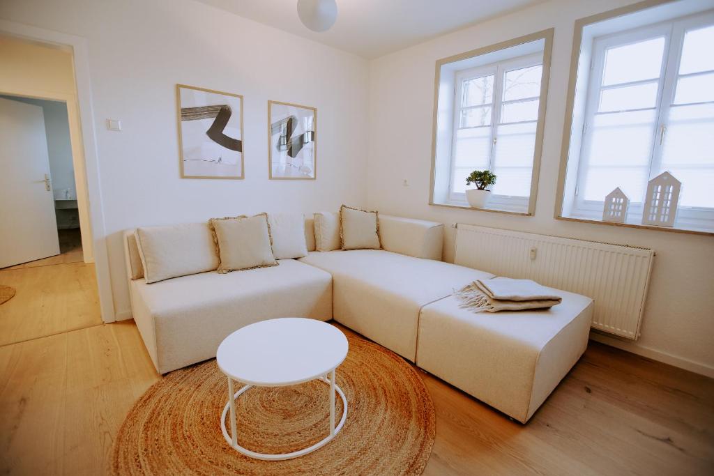 a living room with a white couch and a table at Emsperle in Rietberg