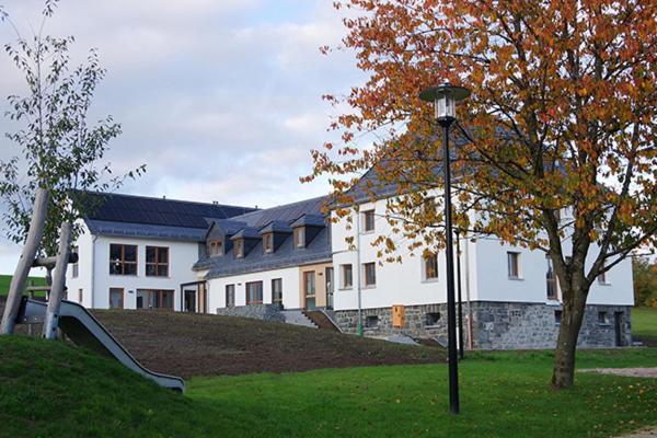 a large white house with a playground in front of it at Das Fränkische Reichenbach in Reichenbach
