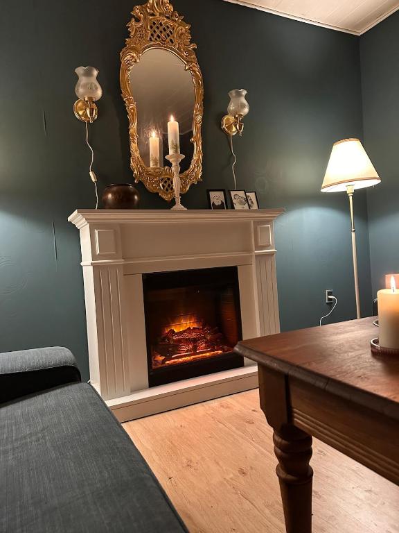 a living room with a fireplace and a mirror at Hyggehuset in Tønder