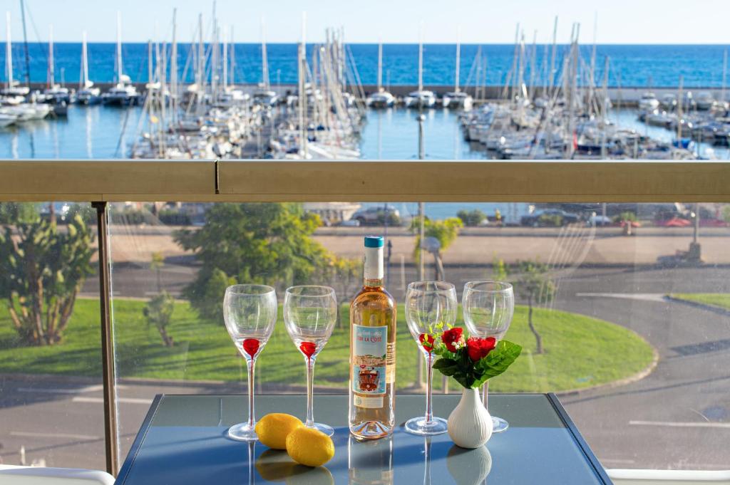 a table with wine glasses and a bottle of wine at Vue mer port de garavan in Menton