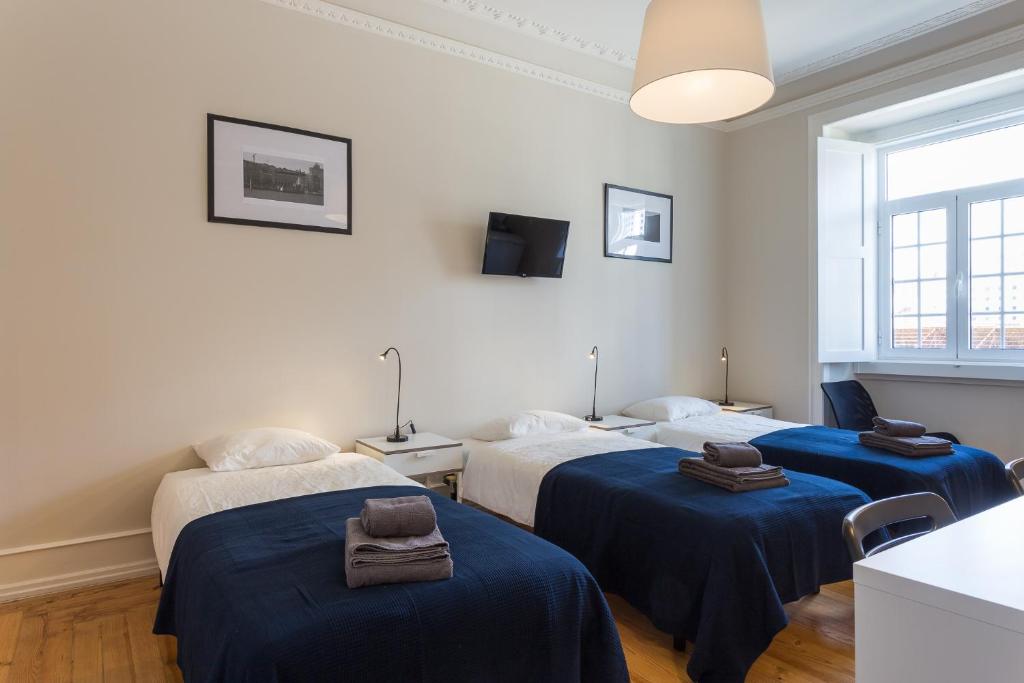 リスボンにあるLxRoller Premium Guesthouseの青いシーツが備わるベッド2台付きの部屋