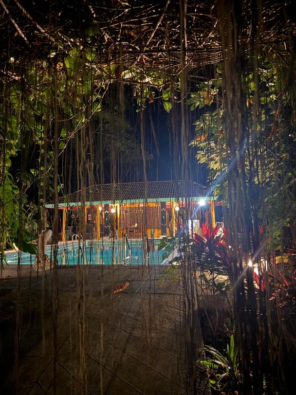a room with a fence and trees at night at Baan Rim Tarn B&B in Takua Pa