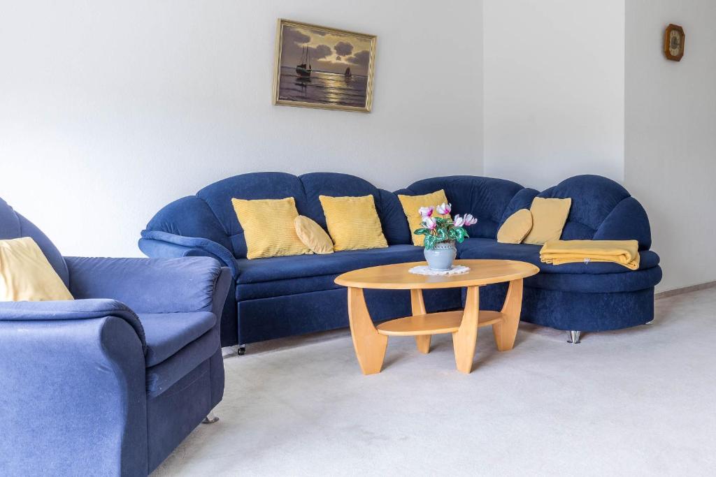 a living room with a blue couch and a table at Ferienwohnung Tina EG in Boltenhagen