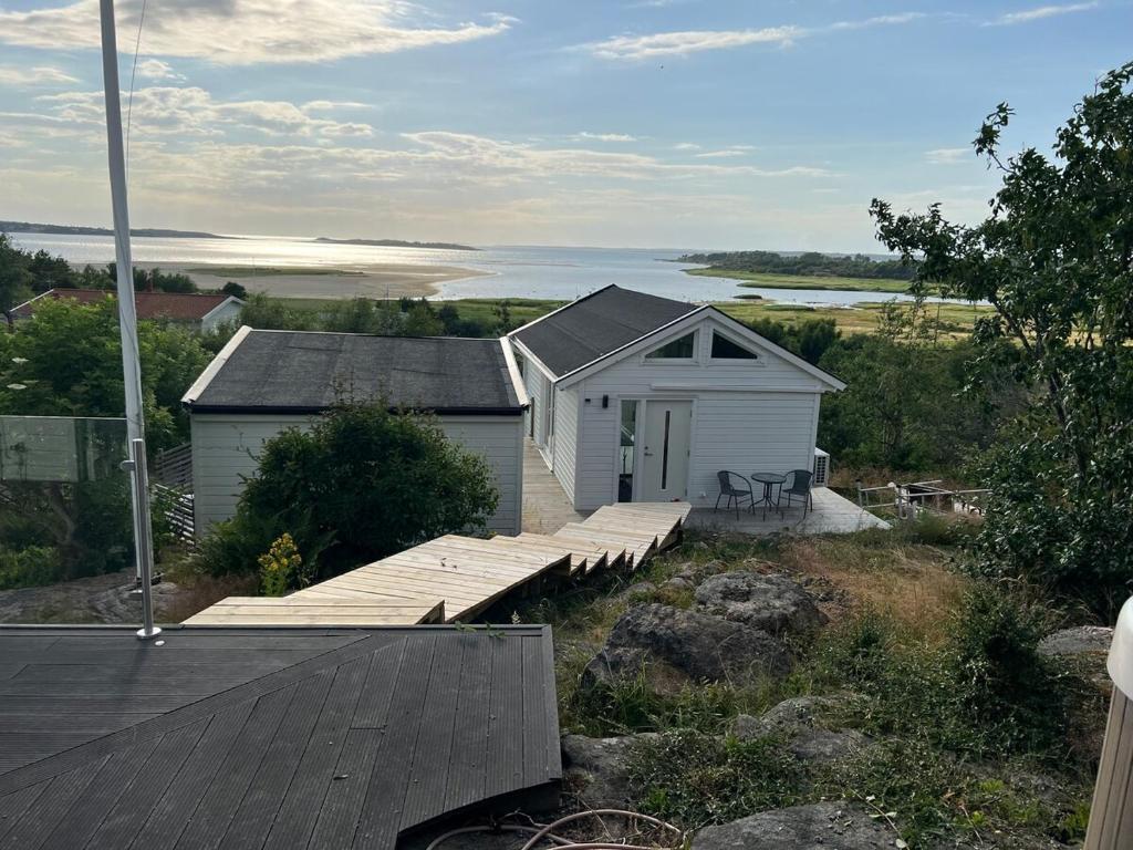 a house with a wooden deck next to a body of water at house with sea view in Varberg