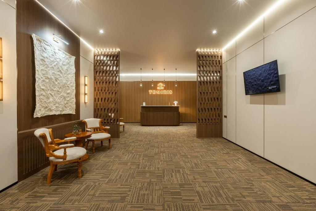 a lobby with a waiting area with chairs and a table at Boutique Hotel Tomiris in Astana