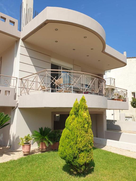 a house with a balcony and a bush at Εξοχικό Σταμάτη in Lóngos