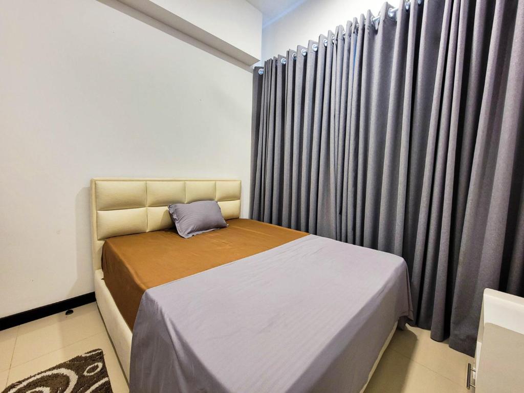 a small bedroom with a bed and curtains at Sea view Apartmen in Trizen in Colombo