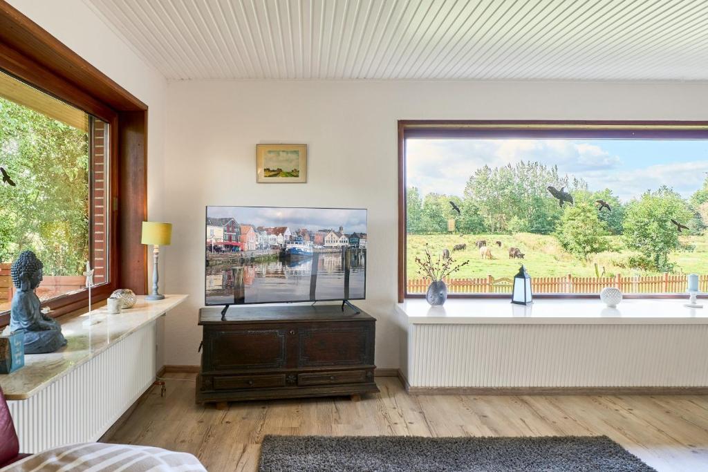 a living room with a large window and a television at Lund36 in Husum