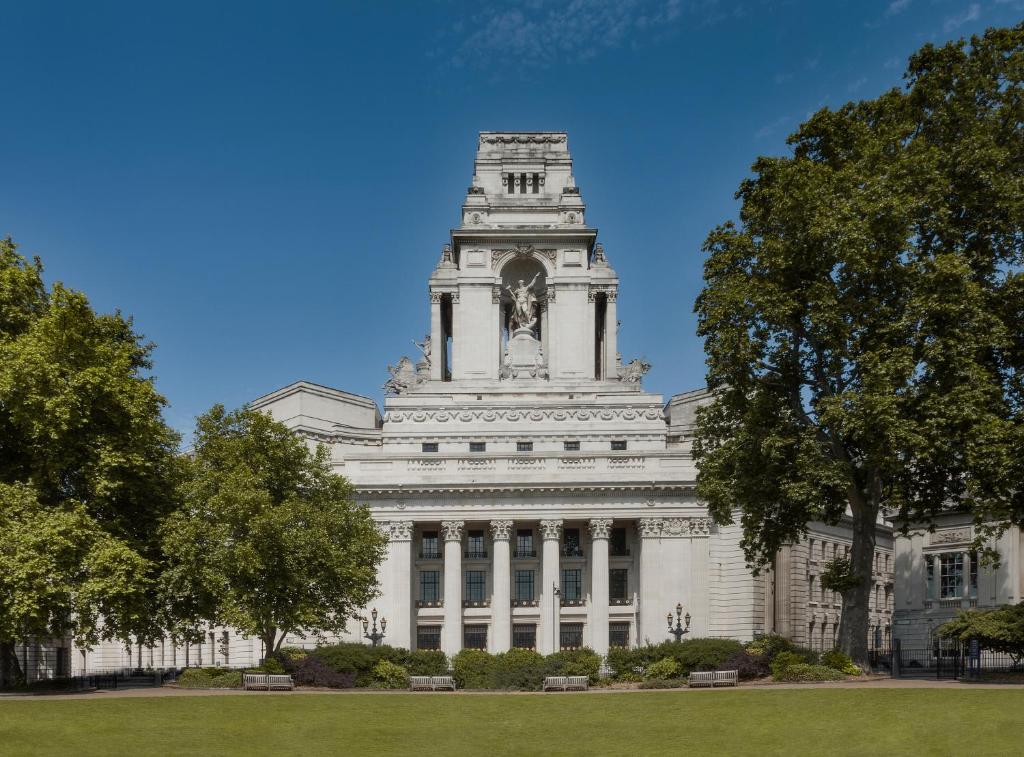 a building with a clock tower on top of it at Four Seasons Hotel London at Ten Trinity Square in London