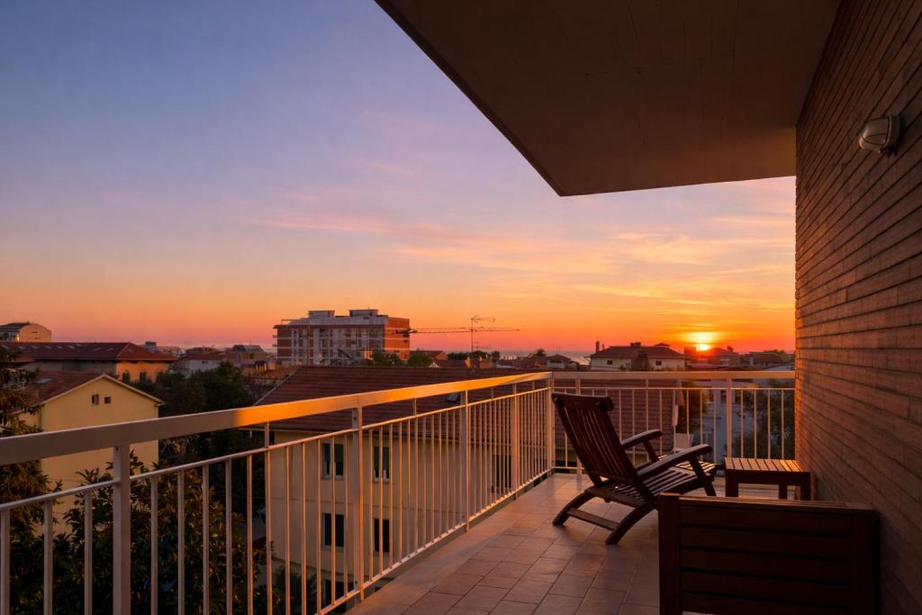 a balcony with two chairs and a sunset at Sea View Solarium- Free parking - 8 min beach - 3 min A14 - Mastrangelo Beach in Grottammare
