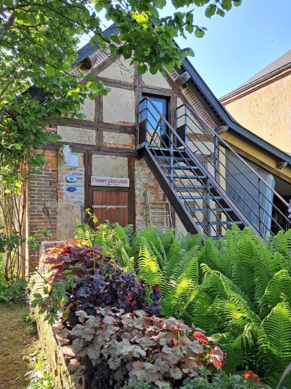 a brick building with a staircase and a bunch of plants at L'atypique du buisson de la gariole in Aubigny-sur-Nère