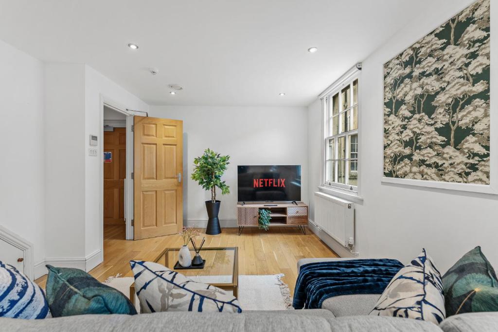 a living room with a couch and a tv at Stylish Roman Bath Abode - The Gatsby in Bath