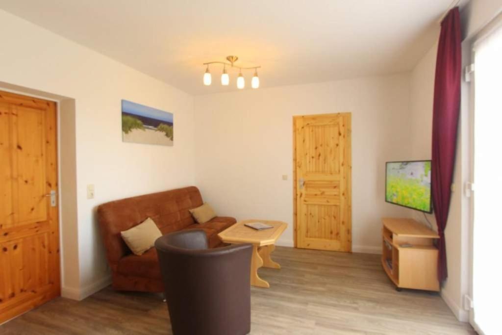 a living room with a couch and a tv at Bungalow Marina Tarnewitz in Tarnewitz