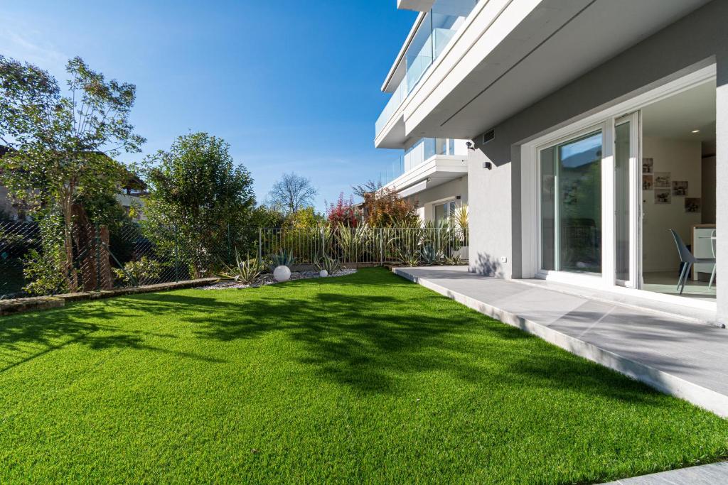a yard with green grass next to a house at Residenza Agave in Boario Terme