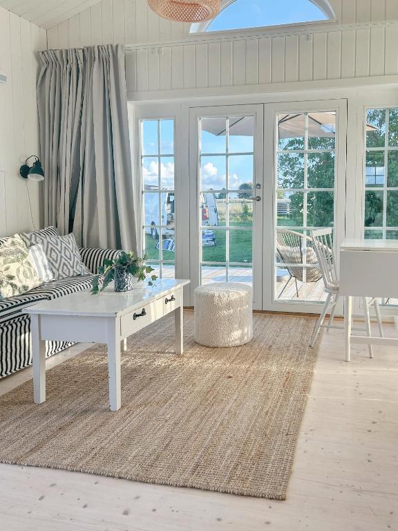 a living room with a couch and a table at Minihus i lantlig miljö nära havet in Smygehamn