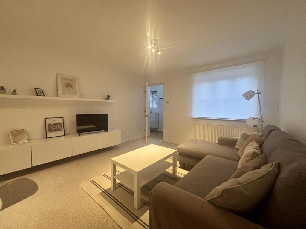 a living room with a couch and a table at Warfield Charming Three Bedroom House in Warfield