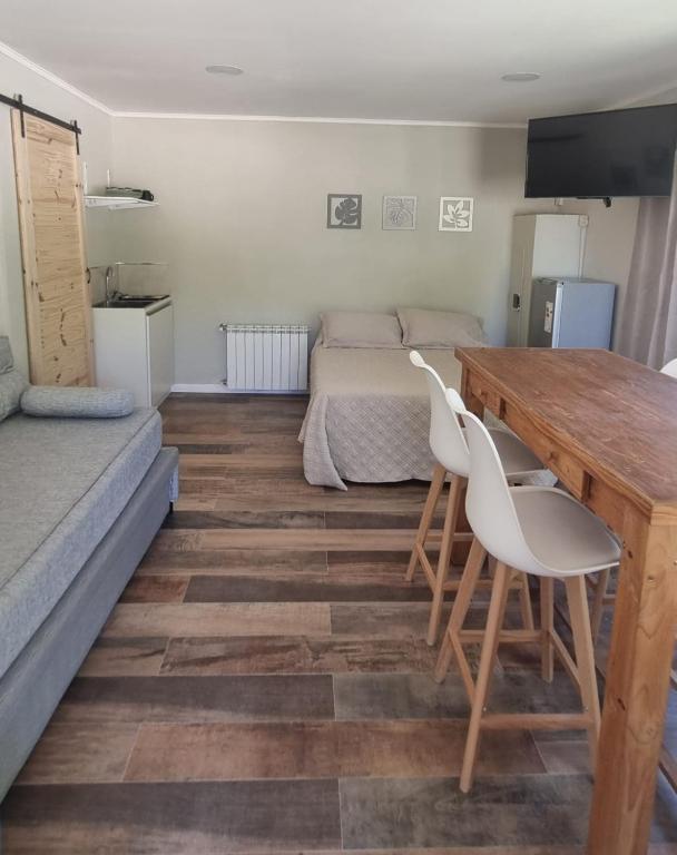 a room with a table and two chairs and a bed at Hospedaje Costanera del Sol in La Adela