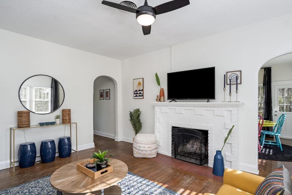 a living room with a fireplace and a flat screen tv at Colorful waterside home in Bradenton