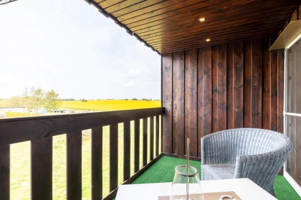 a porch with a table and chairs on a balcony at Ferienwohnung Sterntaler in Goldbeck