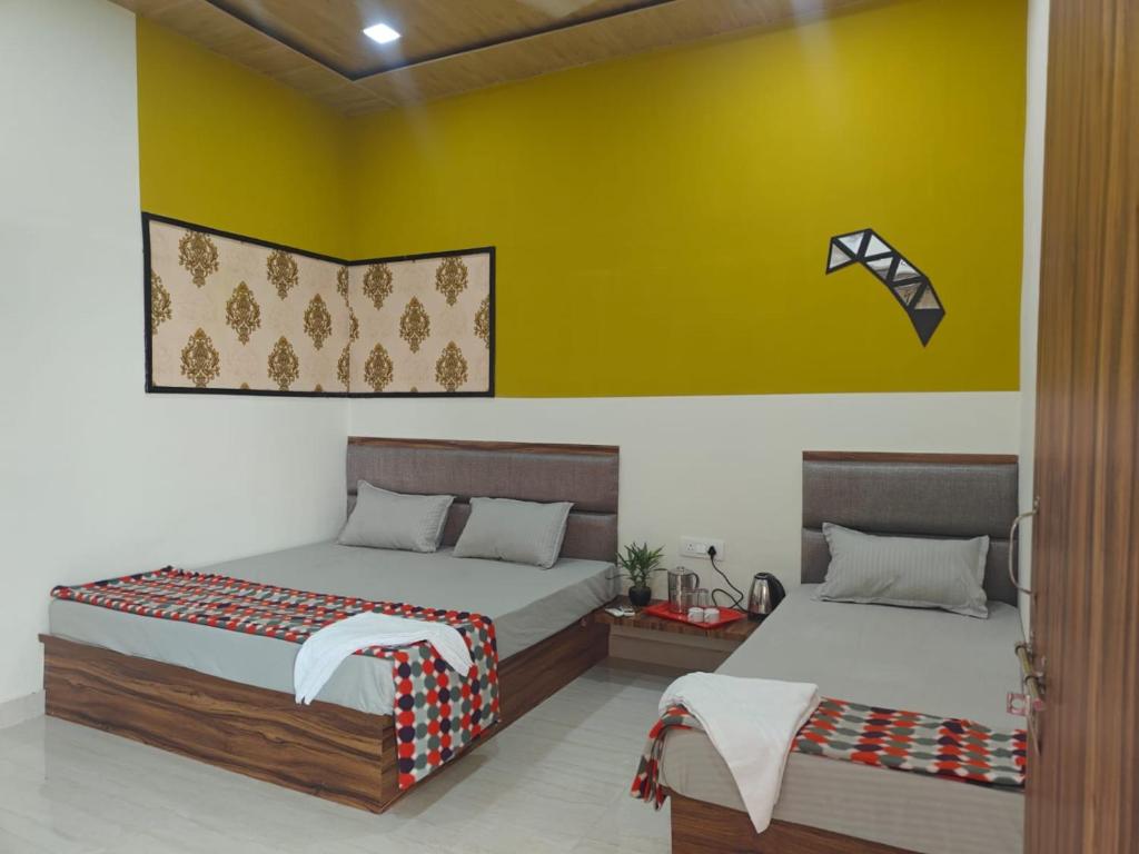 two beds sitting next to each other in a room at Hari Sharnam Residency in Mathura