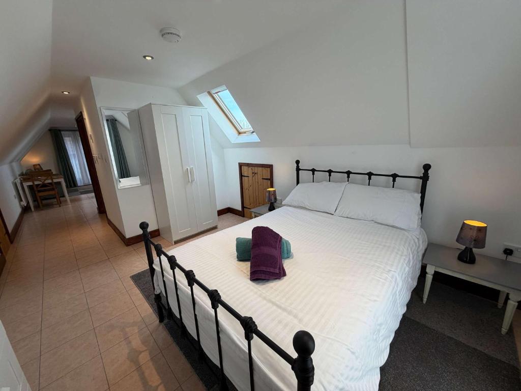 a bedroom with a large white bed with towels on it at Millbrook House Apartments 10 in Milton