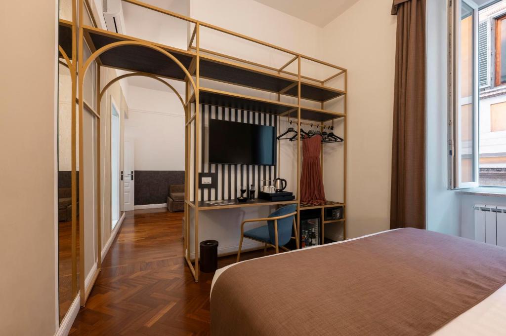 a bedroom with a bed and a desk with a television at Vittoriano Suite in Rome