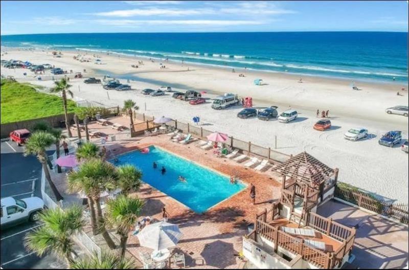 an aerial view of a pool and a beach at Superior beach studio with Pool Access and free parking in Daytona Beach