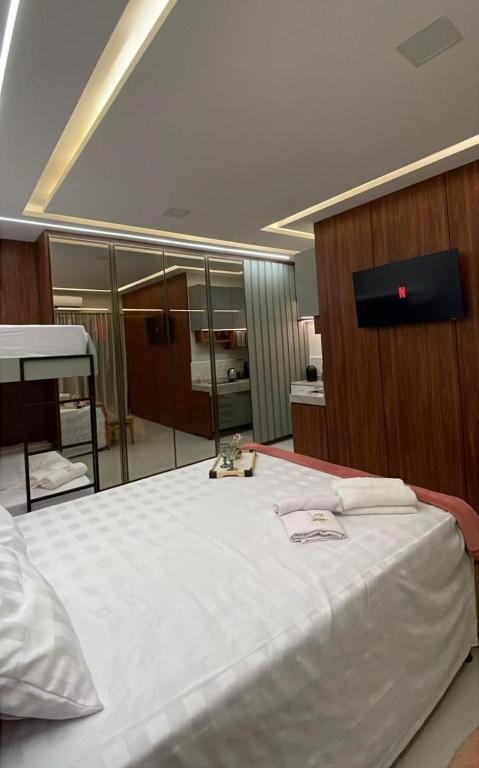 a large white bed in a room with a tv at Flat 02 Residencial ibiapaba in Camocim