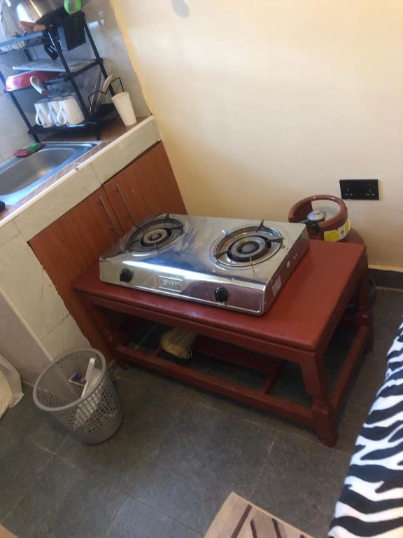 a stove sitting on a table in a kitchen at Hornville suites in Ongata Rongai 