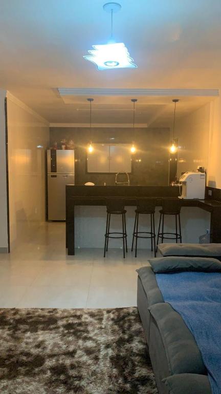 a living room with a couch and a kitchen at Casa aconchegante com piscina e garagem dupla in Búzios