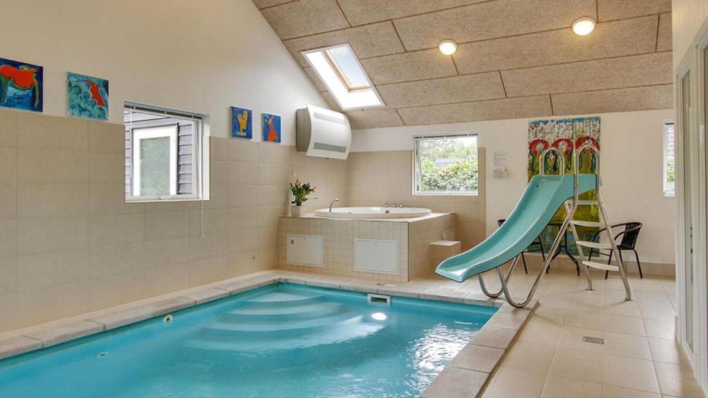 a bathroom with a swimming pool with a slide at Villavilla 171 - Ebeltoft, Østjylland in Ebeltoft