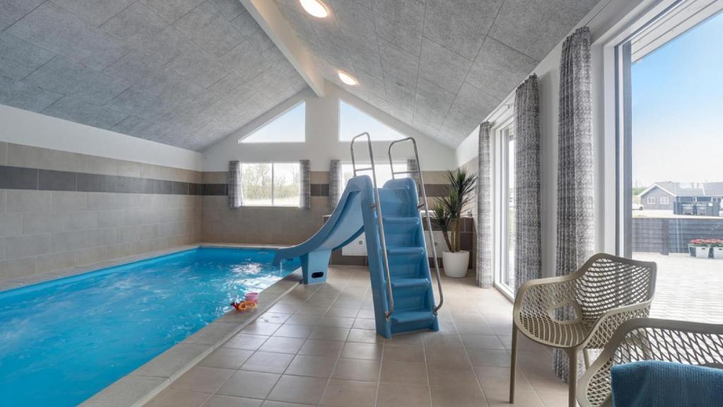 a indoor swimming pool with a slide in a house at Villavilla 441 - Grenå Strand, Østjylland in Grenå