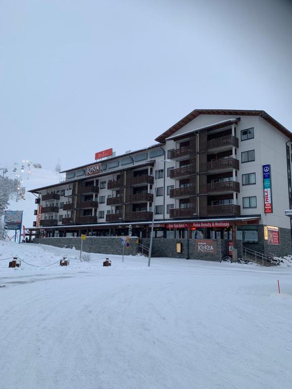 a large apartment building in the snow with a parking lot at Ruka Chalets 1304 high quality apartment in Kuusamo