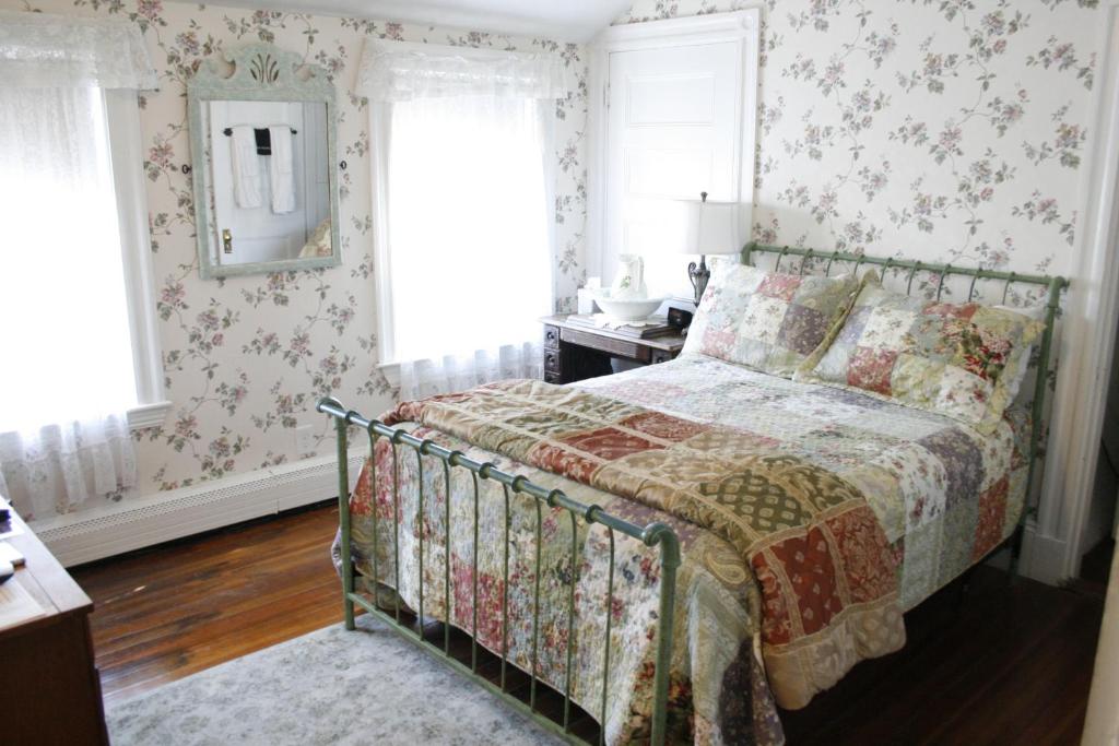 a bedroom with a bed with a quilt on it at The Coolidge Corner Guest House: A Brookline Bed and Breakfast in Brookline
