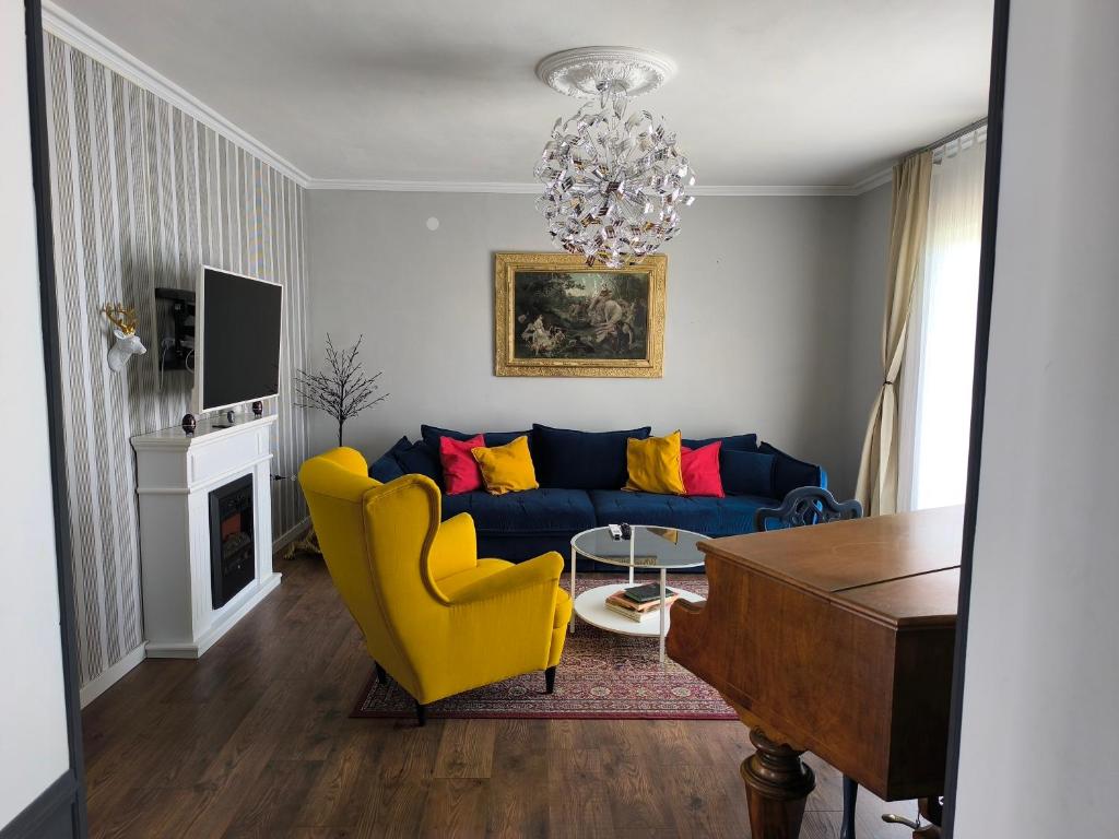 a living room with a blue couch and yellow chairs at Apartments Sabo in Kraljevica