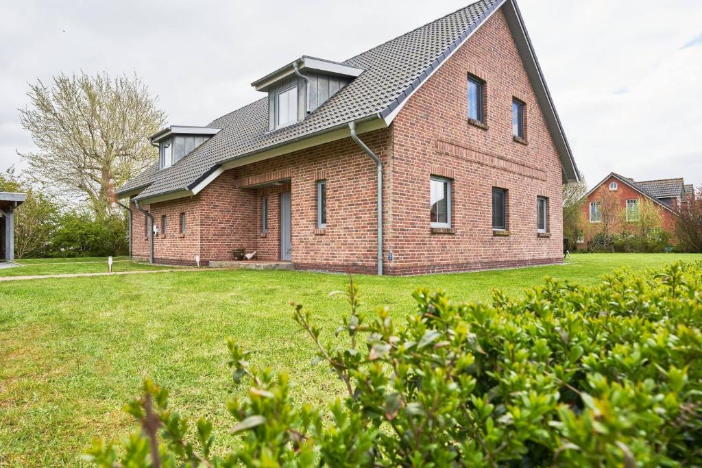 a large brick house with a gambrel roof at Der Wattläufer in Ockholm