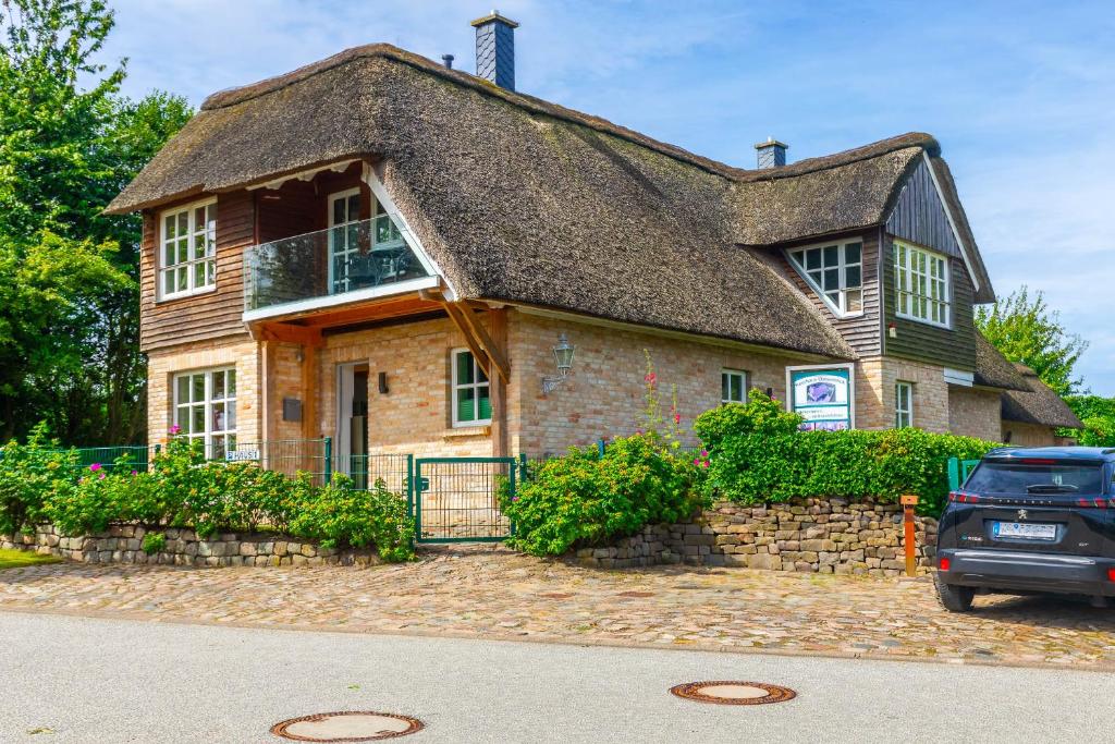 a large brick house with a thatched roof at Reethaus Ostseeblick 1 in Wohlenberg