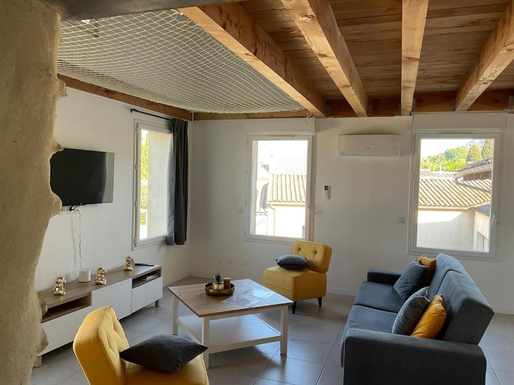 a living room with a blue couch and a tv at spacious cottage with hot tub in Saint-Martin-dʼArdèche