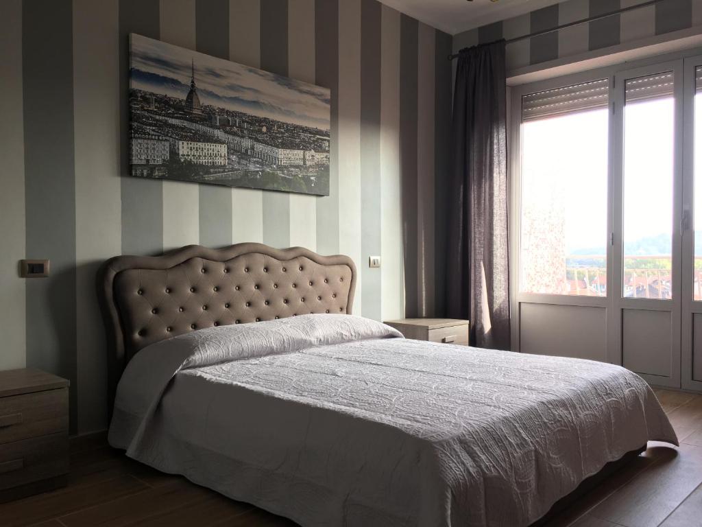 um quarto com uma cama e uma grande janela em Torino BellaVista Inn Apartment em Turim