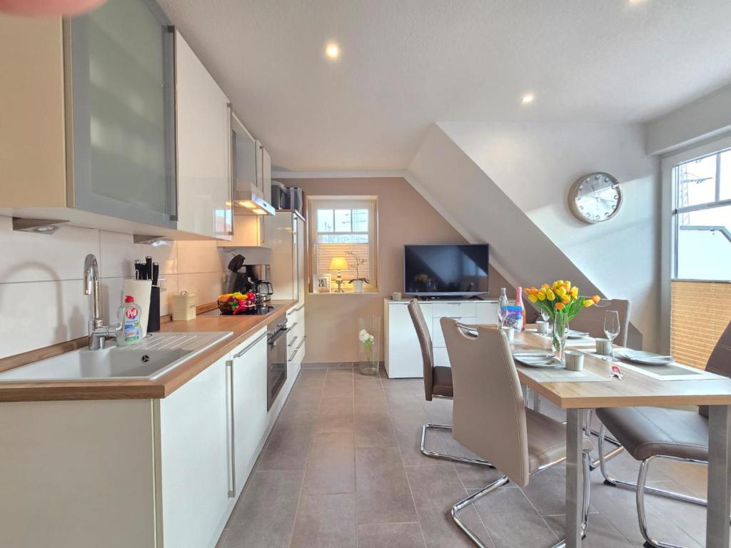 a kitchen with a table and a dining room at Ferienwohnung Meerglück in Norden