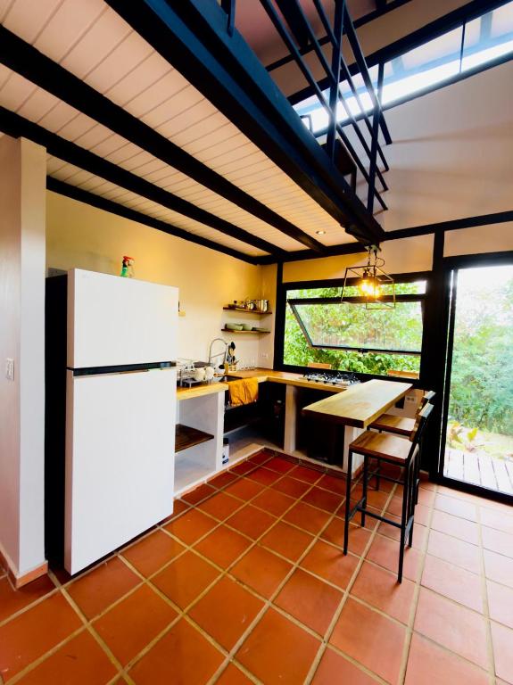 a kitchen with a white refrigerator and a table at Casa Papaya in Los Chacareños